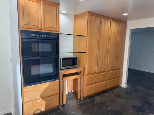 a kitchen with granite countertop cabinets and refrigerator