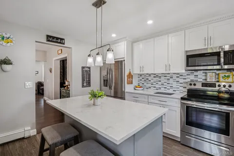 a kitchen with stainless steel appliances a stove a sink a microwave a refrigerator and cabinets