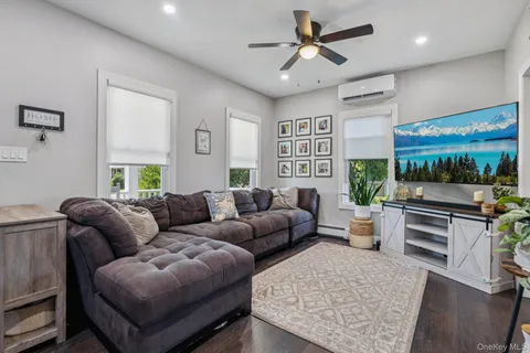 a living room with furniture ceiling fan and a rug