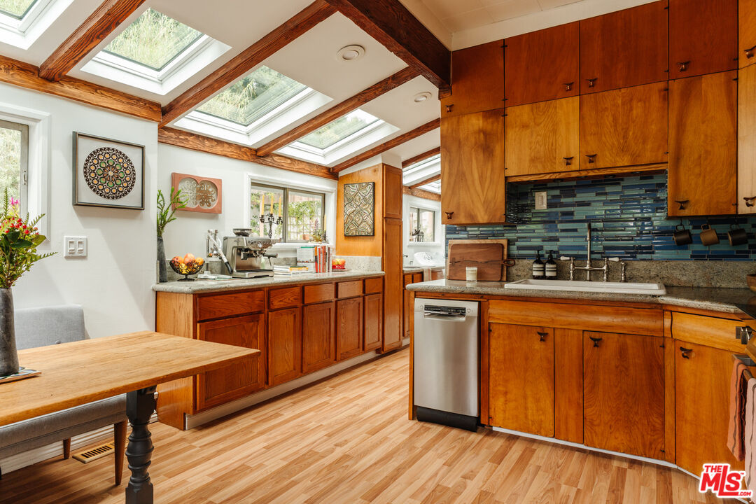 6457 Tokay Road Tujunga, CA 91042 - Photo 23 of 53 a kitchen with stainless steel appliances wooden floors and wooden cabinets