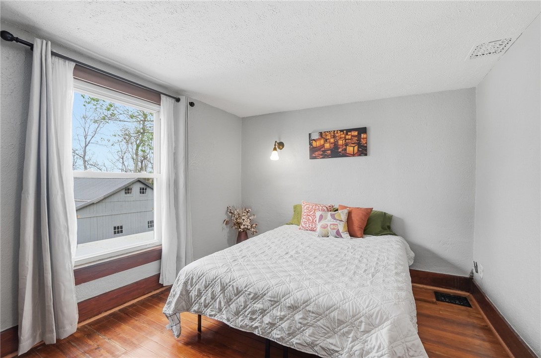 6155 North Union Road Clayton, OH 45315 - Photo 39 of 59 This cozy bedroom features polished wood floors and ample natural light from a large window.