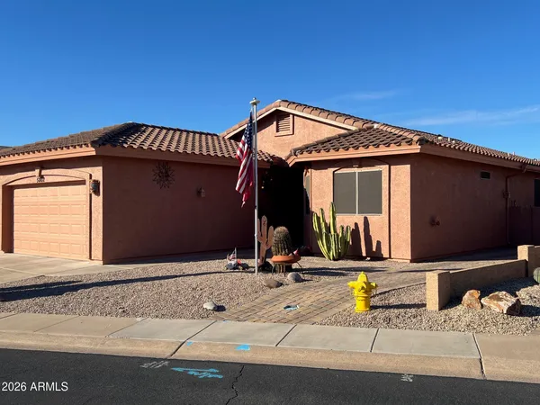 a view of a house with a small yard and large parking space