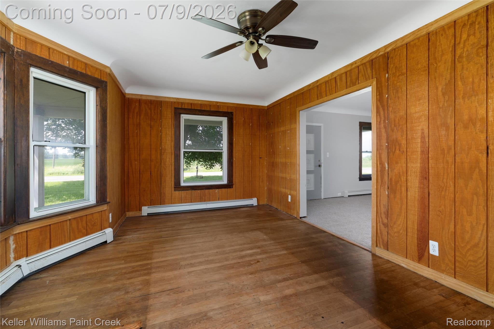 28780 School Section Road Richmond, MI 48062 - Photo 2 of 50 Room featuring wood paneling, wood-finish flooring, a bay window with dark trim, and a ceiling fan with light fixture