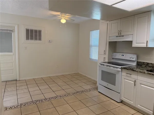 a kitchen with white cabinets a sink dishwasher and a stove top oven