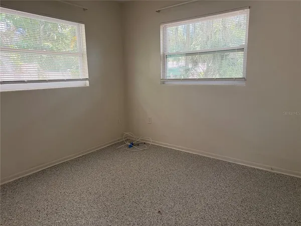 an empty room with windows and closet