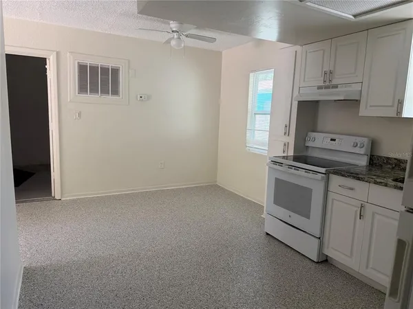 a kitchen with a refrigerator sink stove and cabinets