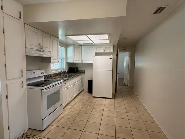 a kitchen with a stove a refrigerator and a sink