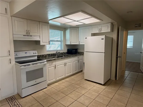 a kitchen with a refrigerator sink stove and cabinets