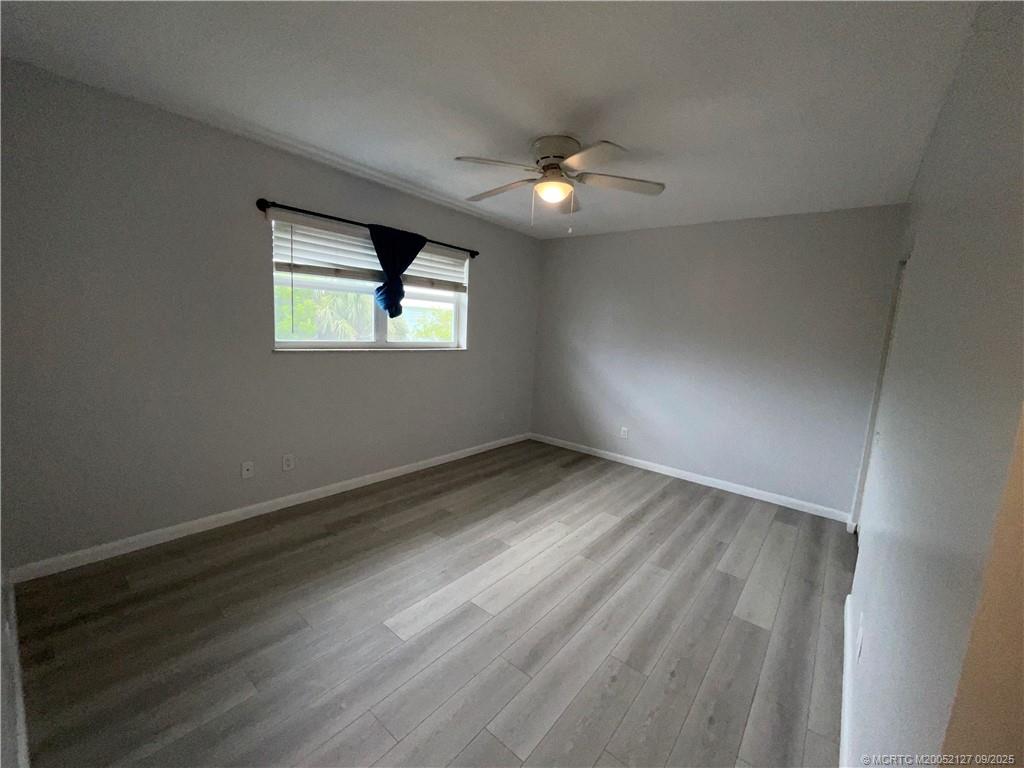 661 Hernando Street, Unit 6 Fort Pierce, FL 34949 - Photo 8 of 12 an empty room with wooden floor and windows
