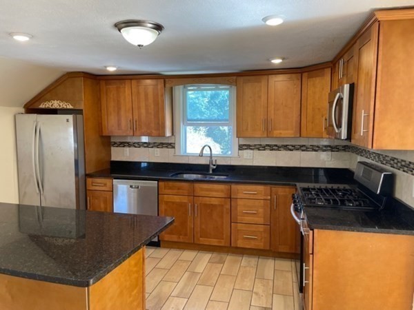 272-2 Nevada Street, Unit 2 Newton, MA 02460 - Photo 2 of 28 a kitchen with stainless steel appliances granite countertop a sink refrigerator and cabinets
