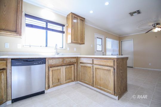 408 South Valley Street Ridgecrest, CA 93555 - Photo 8 of 29 a kitchen with granite countertop cabinets stainless steel appliances a sink and a window