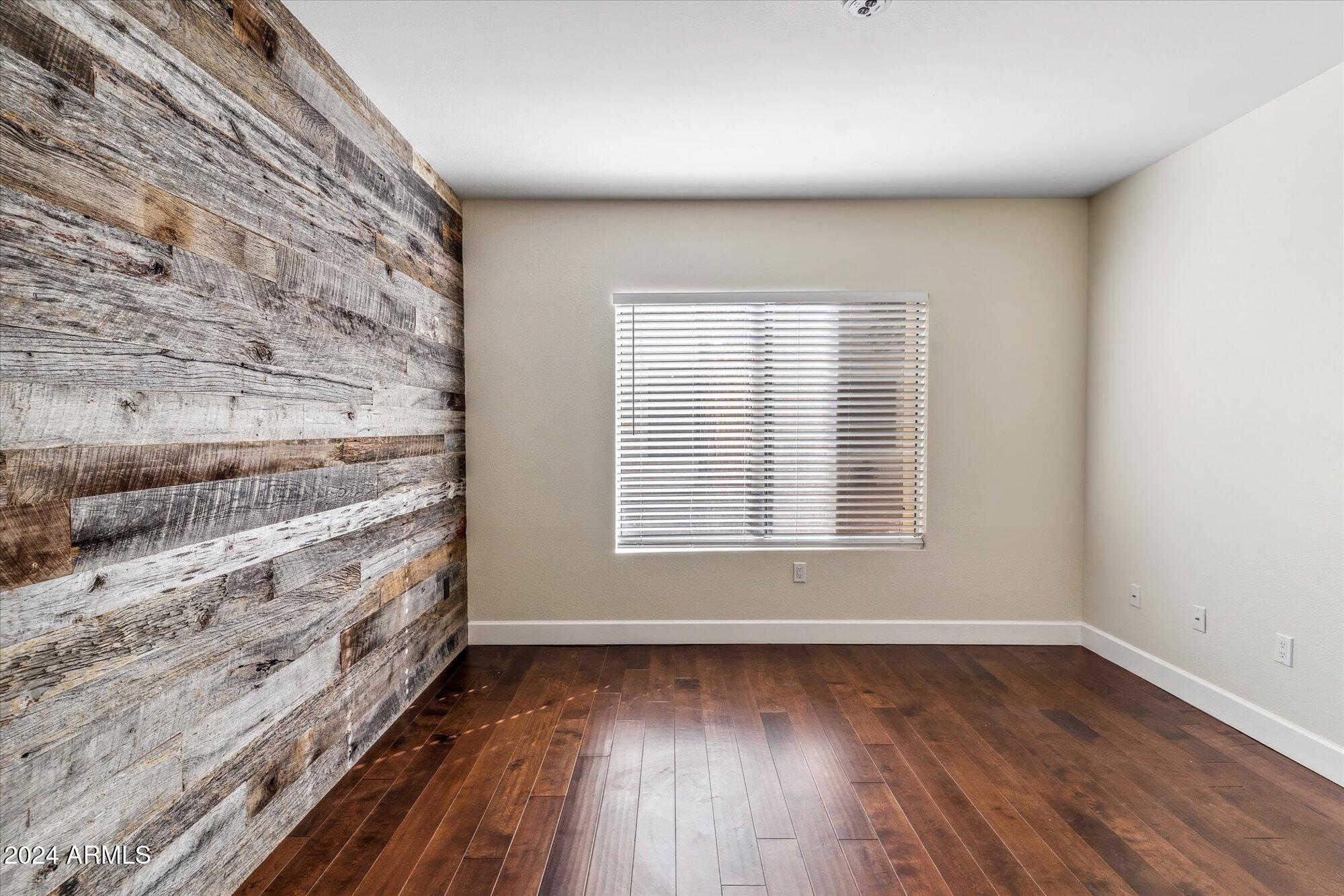 750 East Northern Avenue, Unit 1089 Phoenix, AZ 85020 - Photo 16 of 36 a view of an empty room with wooden floor and a window