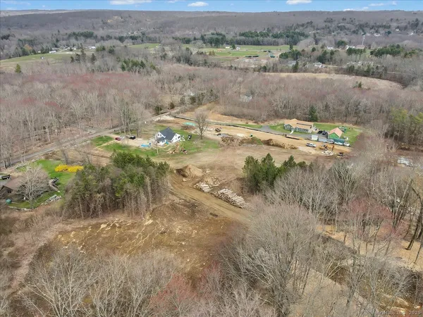 an aerial view of residential houses with outdoor space and trees
