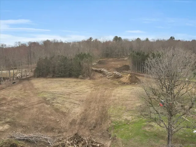 an aerial view of residential houses with outdoor space and trees