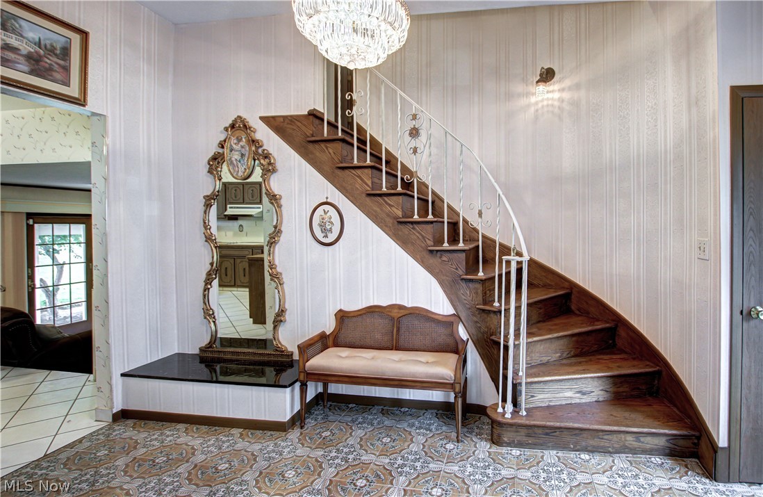 6013 Rousseau Drive Parma, OH 44129 - Photo 19 of 50 Staircase with tile floors and an inviting chandelier