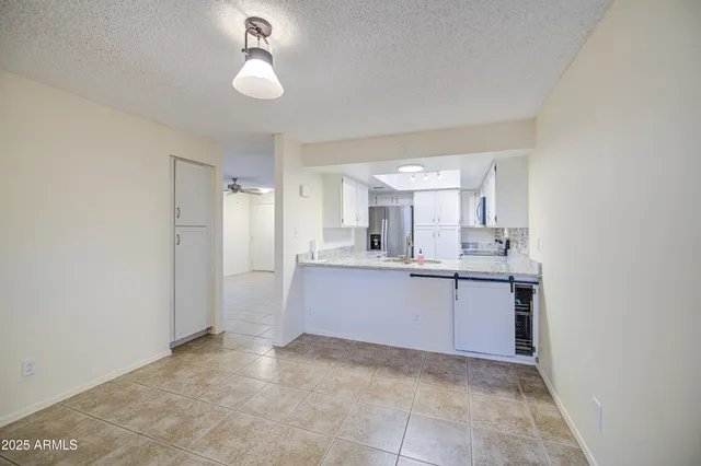a view of an empty room with a ceiling fan and window