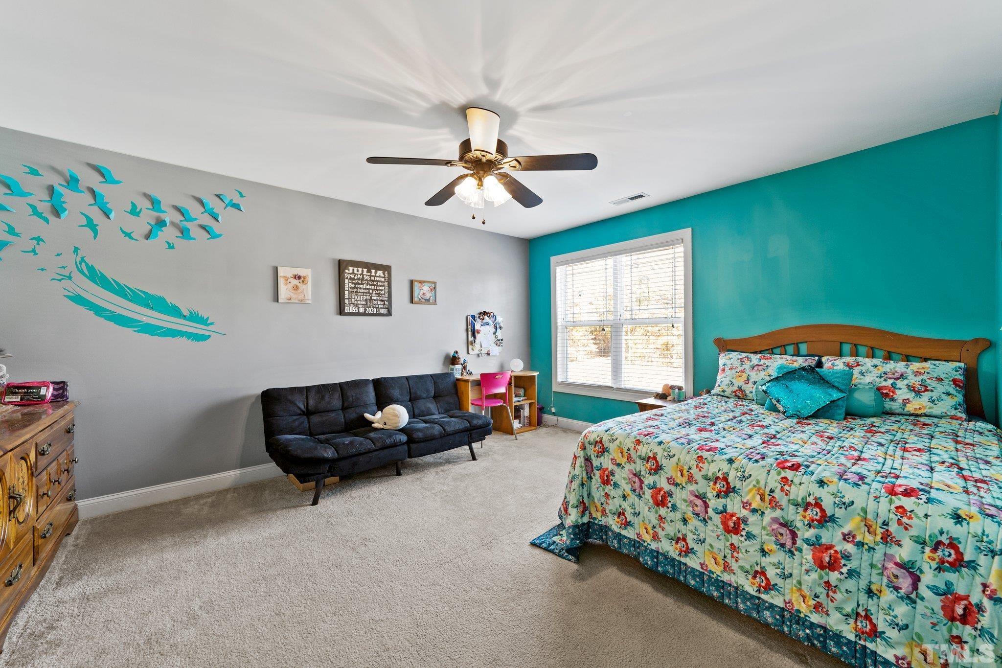 270 Timberland Drive Angier, NC 27501 - Photo 19 of 30 a bedroom with a bed and a chandelier