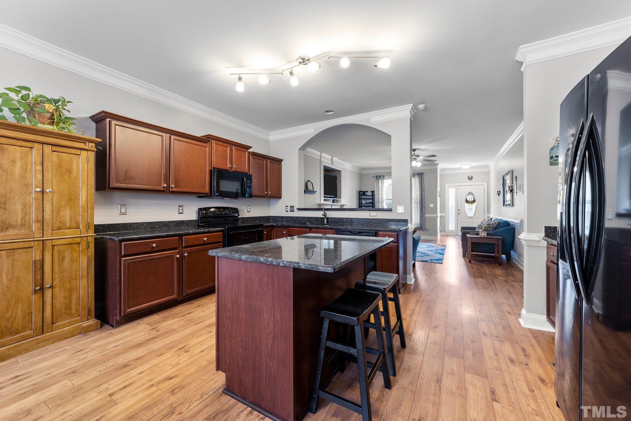 270 Timberland Drive Angier, NC 27501 - Photo 7 of 30 a kitchen with stainless steel appliances granite countertop wooden floors a stove a sink and a refrigerator