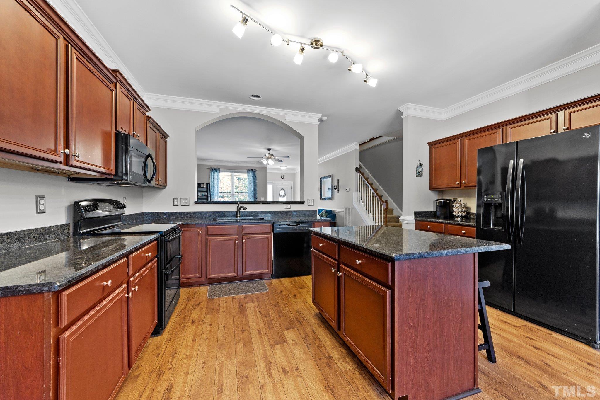 270 Timberland Drive Angier, NC 27501 - Photo 8 of 30 a kitchen with stainless steel appliances granite countertop a stove a refrigerator a sink dishwasher with wooden cabinets and wooden floor