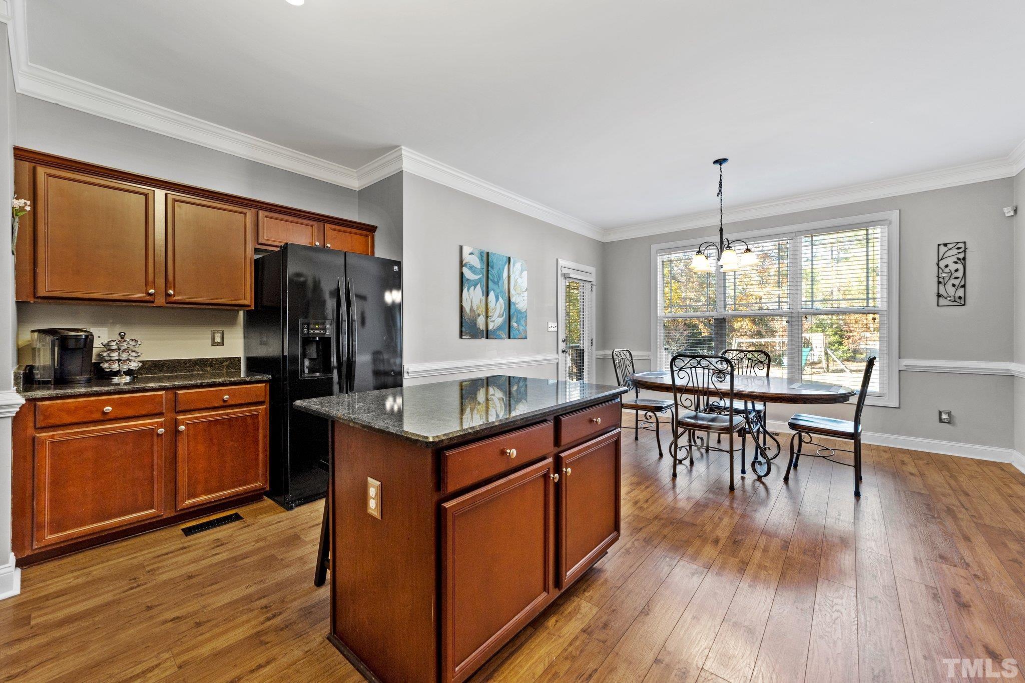 270 Timberland Drive Angier, NC 27501 - Photo 9 of 30 a kitchen with stainless steel appliances granite countertop wooden floors stove refrigerator and wooden cabinets