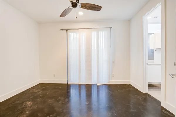 an empty room with wooden floor chandelier fan and closet area