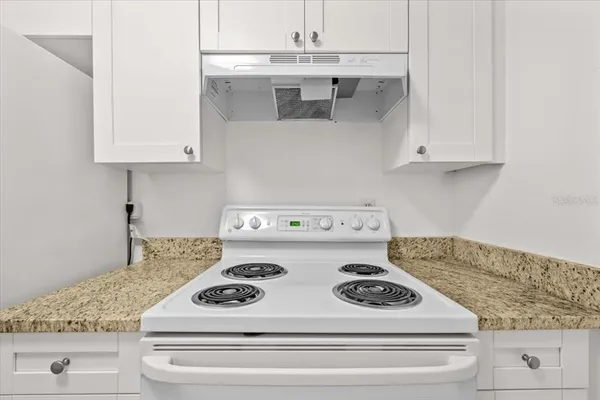 a stove top oven sitting inside of a kitchen