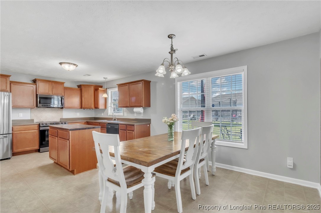 665 Cape Fear Road Raeford, NC 28376 - Photo 9 of 33 a dining room with stainless steel appliances granite countertop a kitchen island a stove a table and chairs