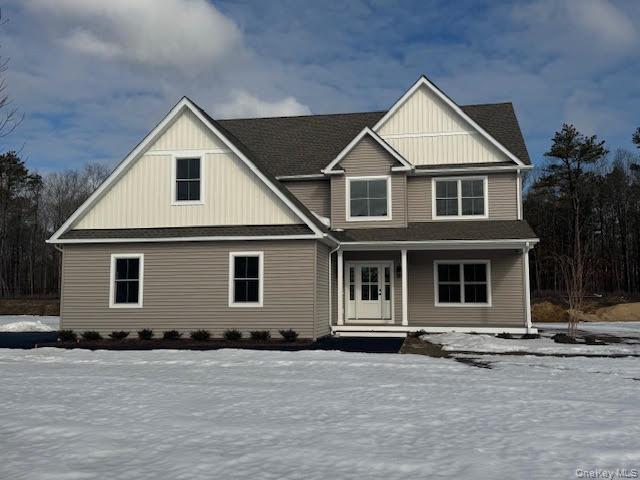 View of front of house with covered porch, board and batten siding, and roof with shingles