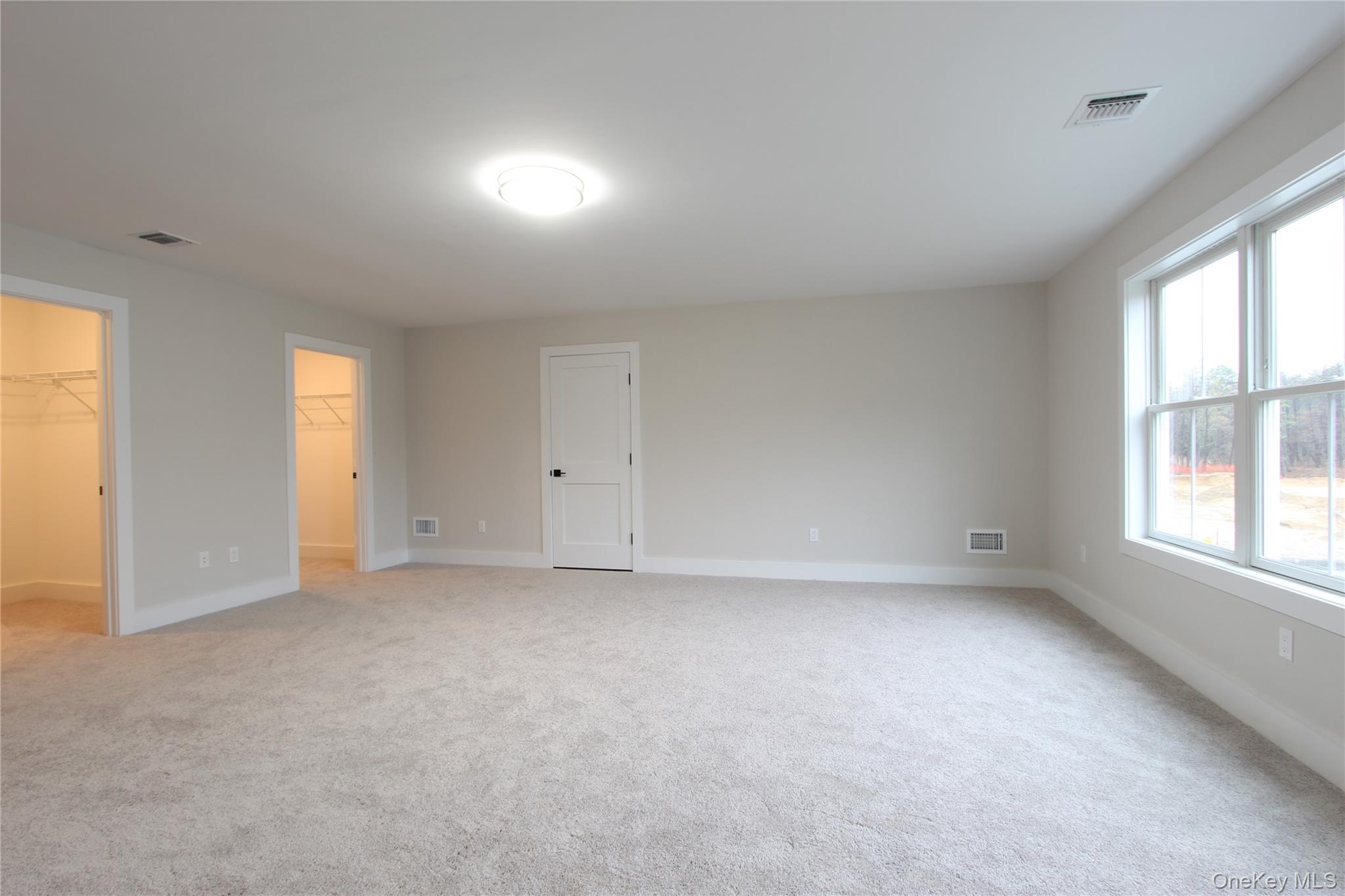 5 Colonels Path Manorville, NY 11949 - Photo 15 of 30 Unfurnished bedroom featuring 2 walk in closet and light carpet