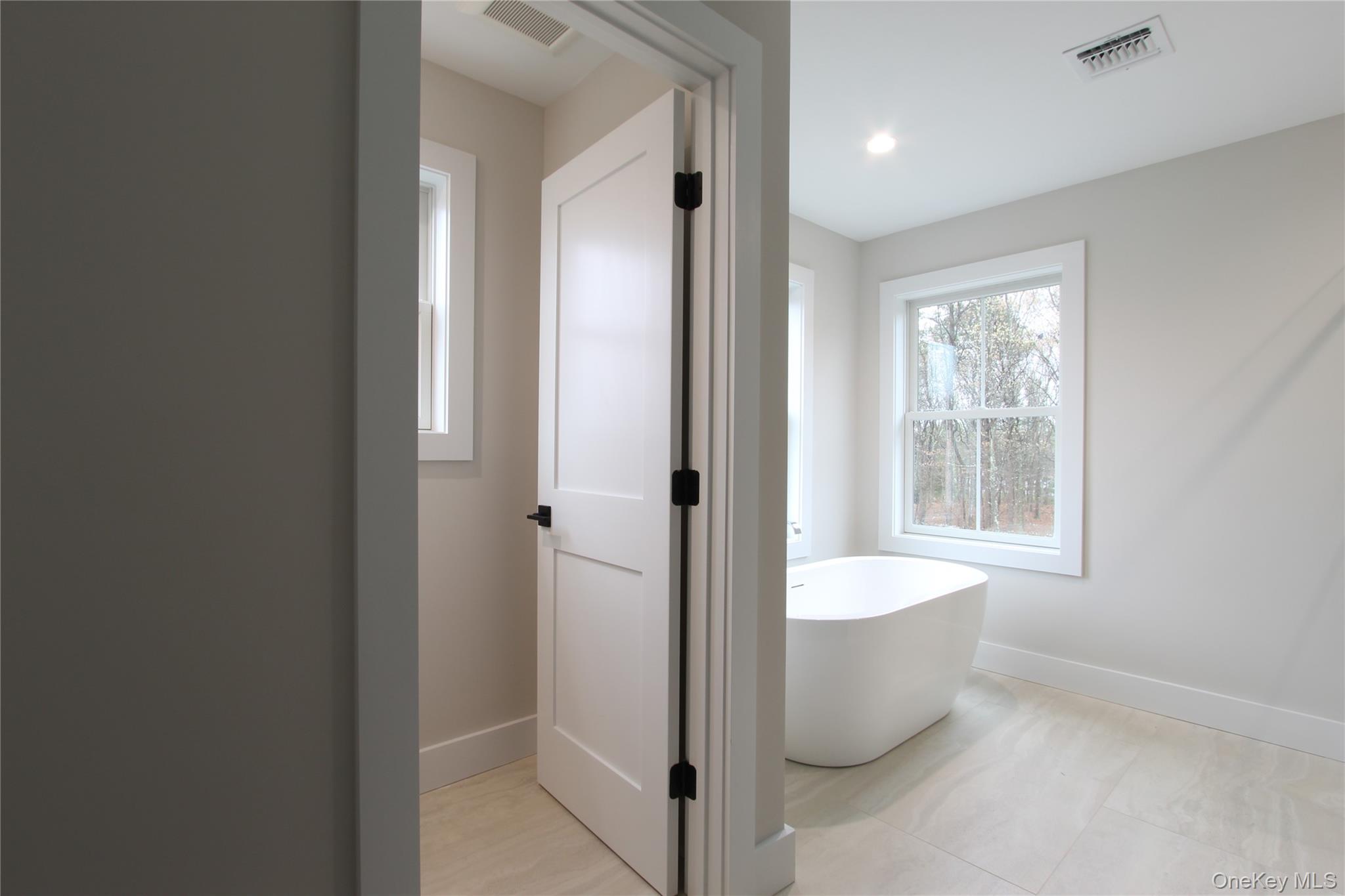 5 Colonels Path Manorville, NY 11949 - Photo 18 of 19 Full bath featuring a freestanding bath and baseboards