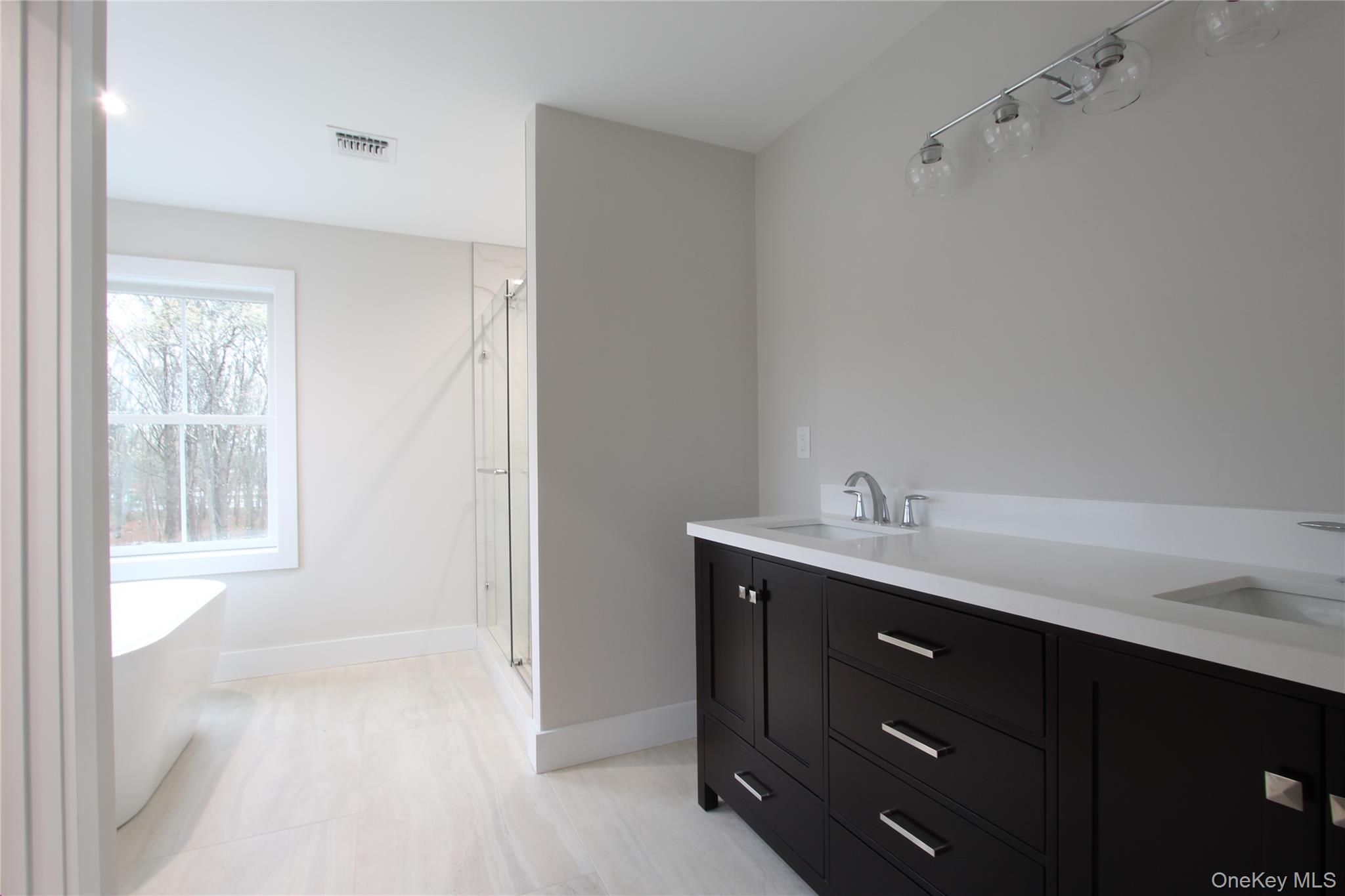 5 Colonels Path Manorville, NY 11949 - Photo 19 of 19 Bathroom featuring a freestanding bath, a stall shower, and double vanity