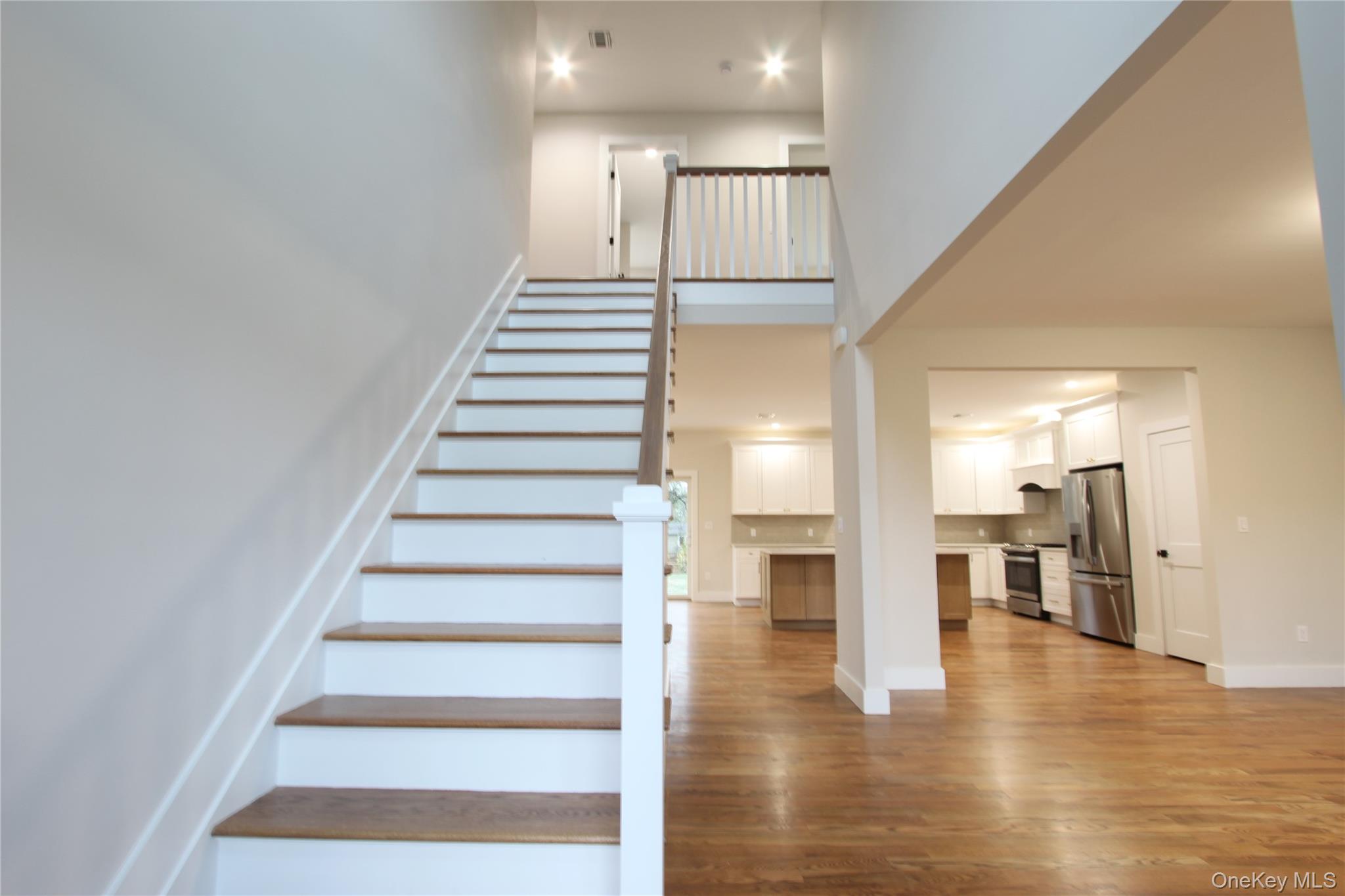 5 Colonels Path Manorville, NY 11949 - Photo 3 of 19 Staircase featuring recessed lighting, wood finished floors, and a high ceiling