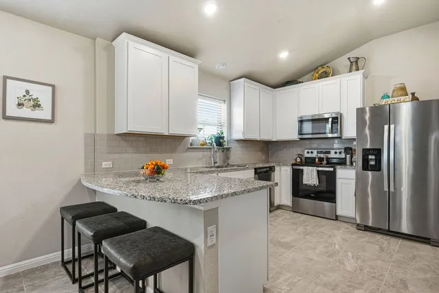 a kitchen with a refrigerator cabinets and wooden floor