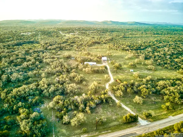 an aerial view of residential houses with outdoor space and trees