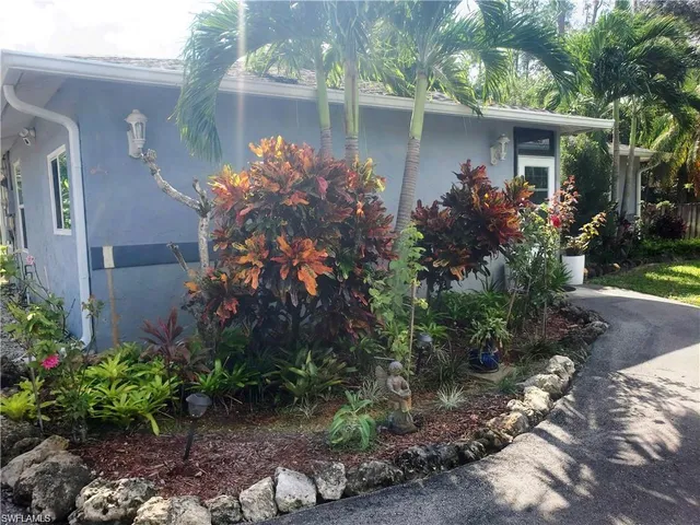 a front view of a house with plants