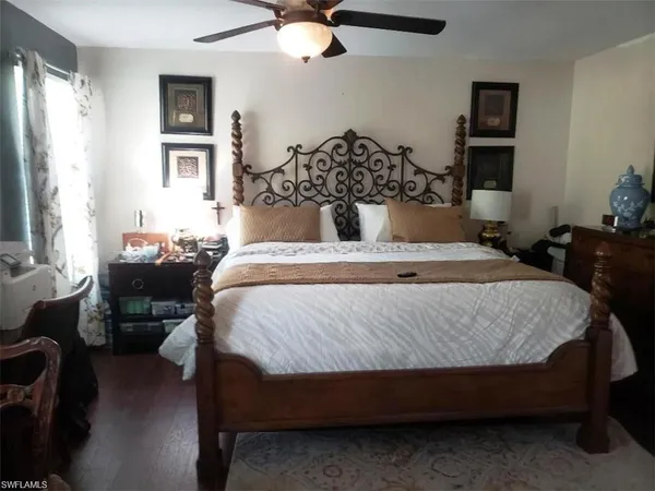 a bed sitting in a bedroom next to a window with a chandelier