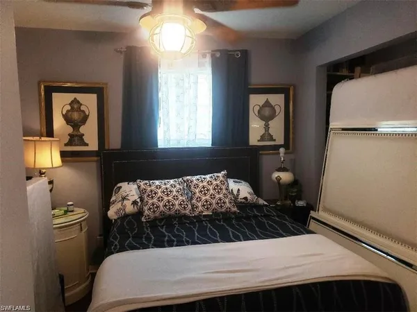 a bedroom with a bed and dresser with mirror