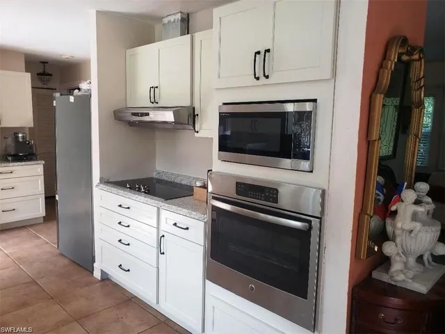 a kitchen with stainless steel appliances white cabinets and a stove