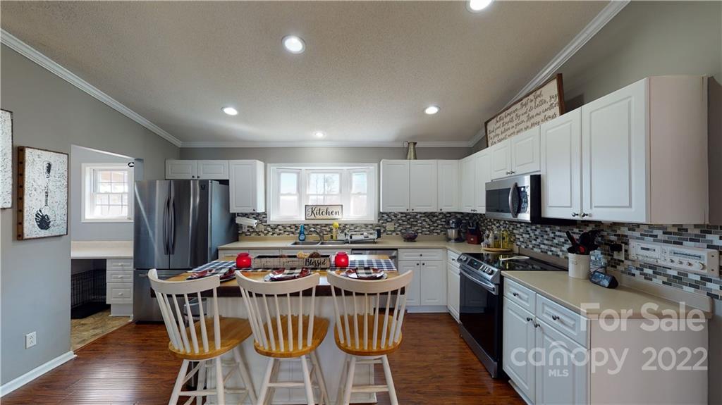 2130 Peeler Road Vale, NC 28168 - Photo 10 of 29 a kitchen with stainless steel appliances kitchen island granite countertop a stove a sink a refrigerator a center island and a refrigerator