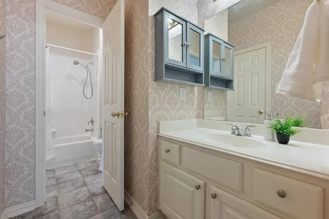 a bathroom with a white toilet sitting next to a white sink and a shower curtain