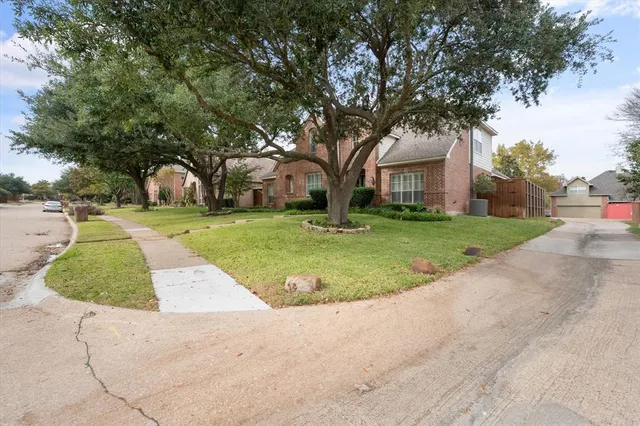 front view of a house with a yard and an trees