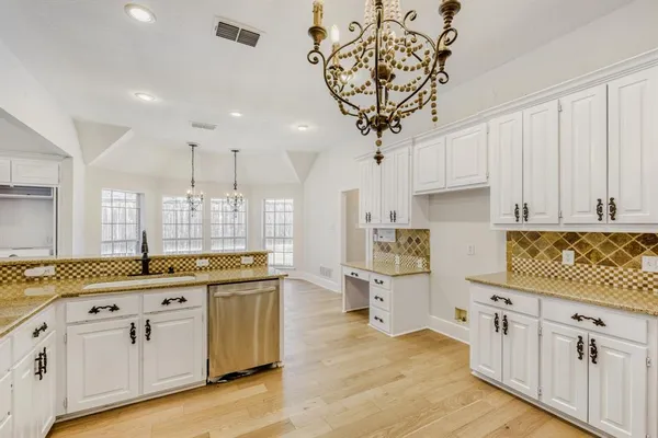 a kitchen with stainless steel appliances granite countertop a sink a stove and cabinets