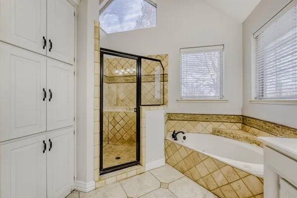 a spacious bathroom with a granite countertop tub shower and mirror