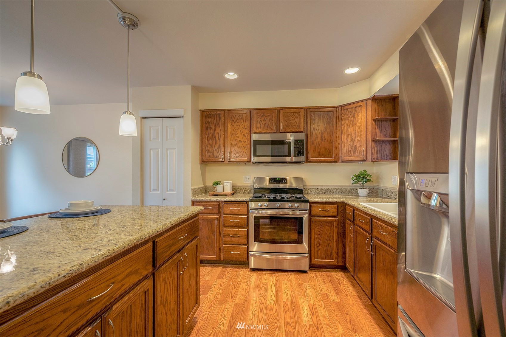 18807 19th Drive Southeast Bothell, WA 98012 - Photo 4 of 18 a kitchen with stainless steel appliances granite countertop a sink a stove a refrigerator and cabinets