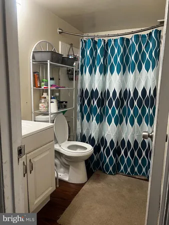a bathroom with a toilet and a shower curtain