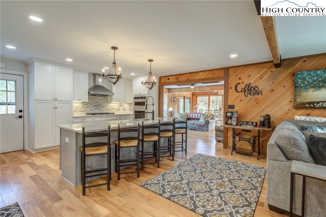 389 Auborn Trivette Road Sugar Grove, NC 28679 - Photo 13 of 49 a open kitchen with stainless steel appliances granite countertop a stove a refrigerator a oven a dining table and chairs with wooden floor