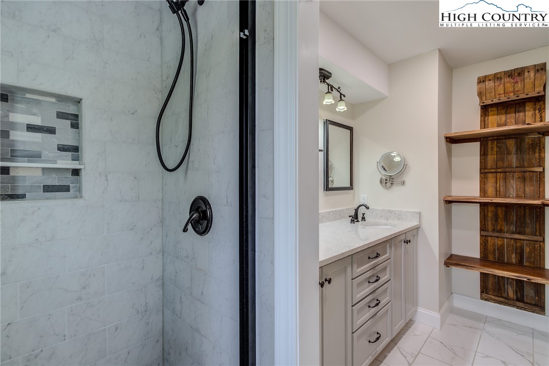 389 Auborn Trivette Road Sugar Grove, NC 28679 - Photo 27 of 49 a bathroom with a shower a mirror and a sink