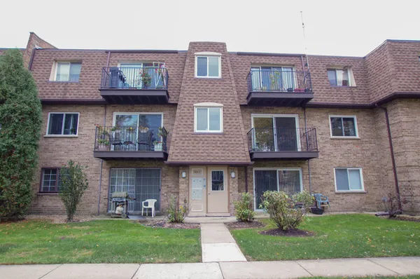a front view of a brick house with a yard