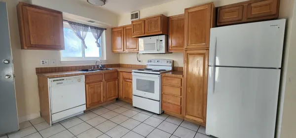 a white refrigerator freezer and a stove in a kitchen