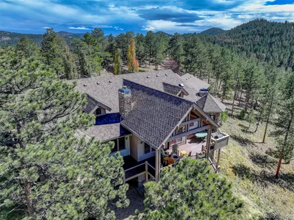 an aerial view of a house with a yard and mountain